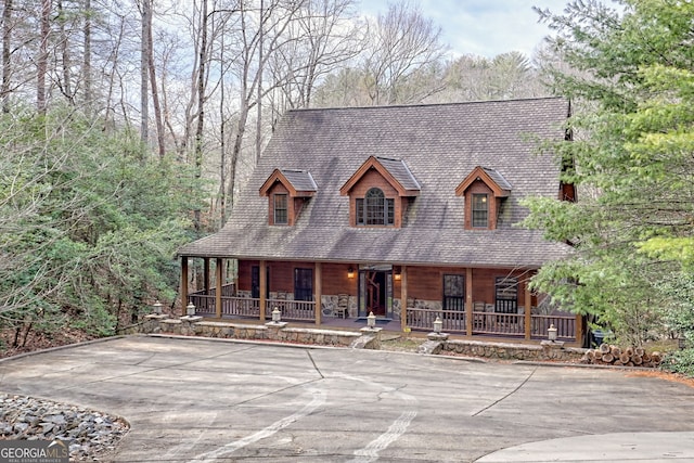 view of front of property with a porch and basketball hoop