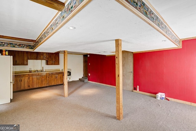 basement featuring carpet flooring, white fridge, and sink