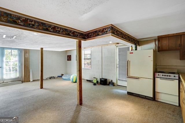 basement with white fridge, carpet floors, and a textured ceiling