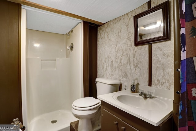 bathroom with a textured ceiling, vanity, toilet, and walk in shower