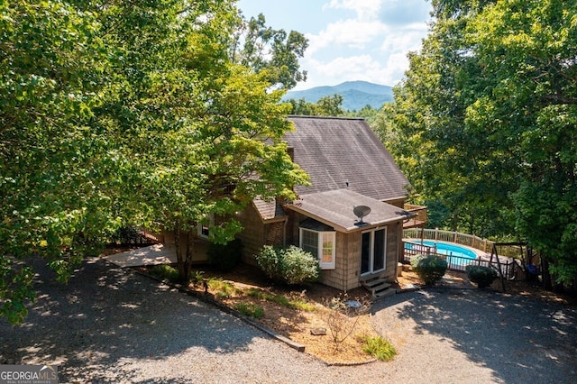 view of front facade with a fenced in pool and a mountain view