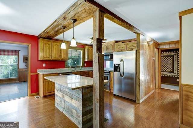 kitchen featuring pendant lighting, stainless steel appliances, dark hardwood / wood-style flooring, a kitchen island, and sink