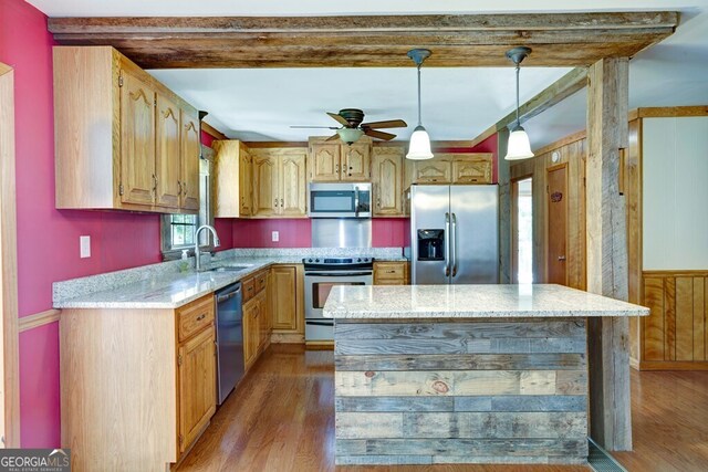 kitchen with light wood-type flooring, light stone countertops, stainless steel appliances, and ceiling fan