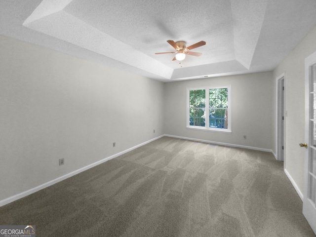 carpeted empty room with a textured ceiling, a raised ceiling, and ceiling fan