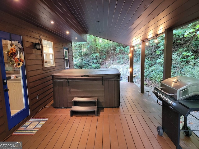 wooden deck with a hot tub and a grill