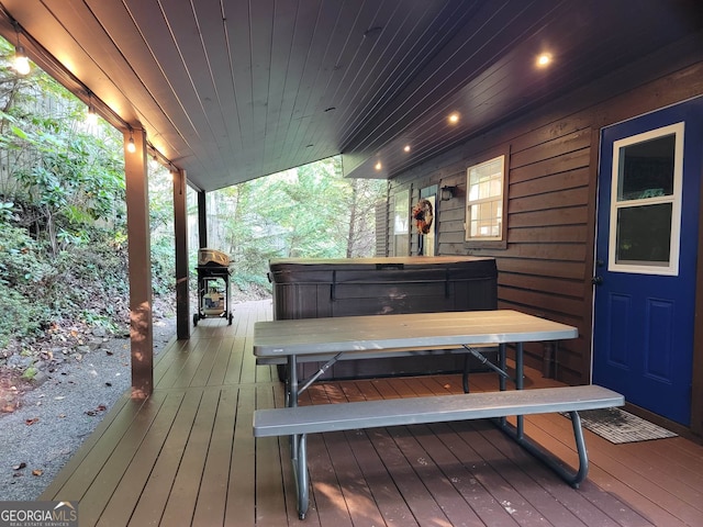 wooden terrace with grilling area and a hot tub