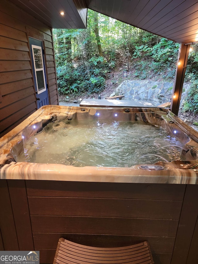 details with wood ceiling, a hot tub, and wooden walls