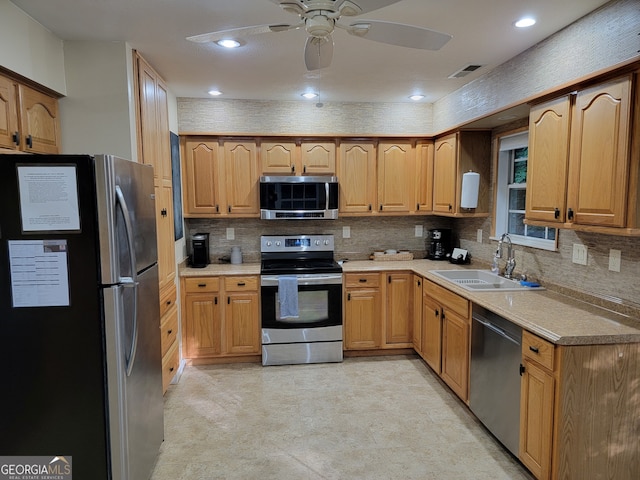 kitchen featuring appliances with stainless steel finishes, backsplash, sink, and ceiling fan