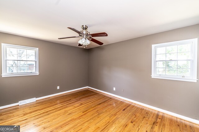 empty room with hardwood / wood-style flooring and ceiling fan