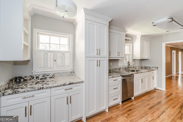 kitchen featuring light stone countertops, dishwasher, sink, white cabinetry, and light wood-type flooring