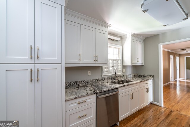 kitchen featuring light hardwood / wood-style floors, stainless steel dishwasher, sink, white cabinetry, and light stone counters