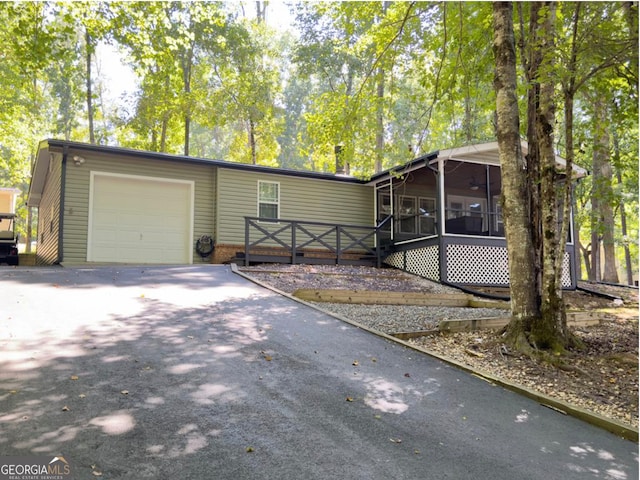 view of front of property with a garage and a sunroom