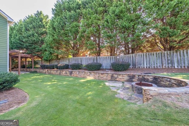 view of yard with a fire pit and a pergola