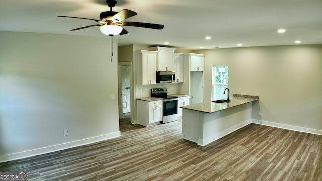 kitchen featuring appliances with stainless steel finishes, white cabinetry, hardwood / wood-style floors, and ceiling fan