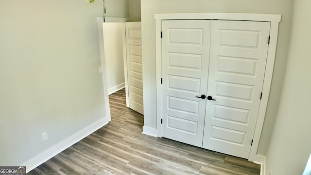 unfurnished bedroom featuring a closet and hardwood / wood-style flooring