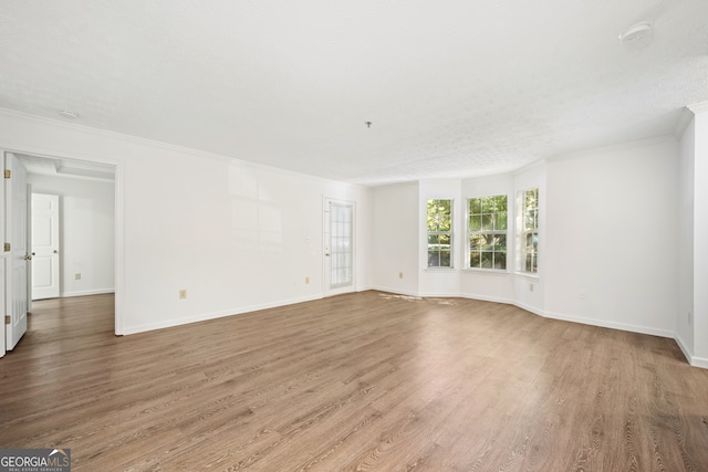 unfurnished room featuring hardwood / wood-style flooring, crown molding, and a textured ceiling