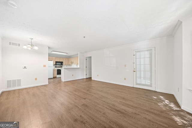 unfurnished living room featuring crown molding, a chandelier, light hardwood / wood-style flooring, and a textured ceiling