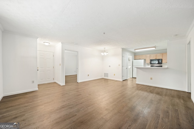 unfurnished living room with dark hardwood / wood-style floors, an inviting chandelier, ornamental molding, and a textured ceiling