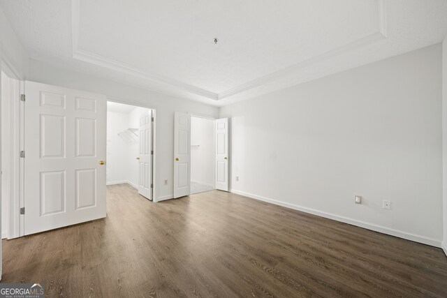 interior space featuring a tray ceiling and dark hardwood / wood-style flooring