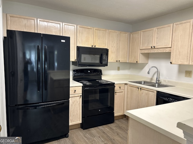 kitchen with light hardwood / wood-style floors, light brown cabinets, black appliances, and sink