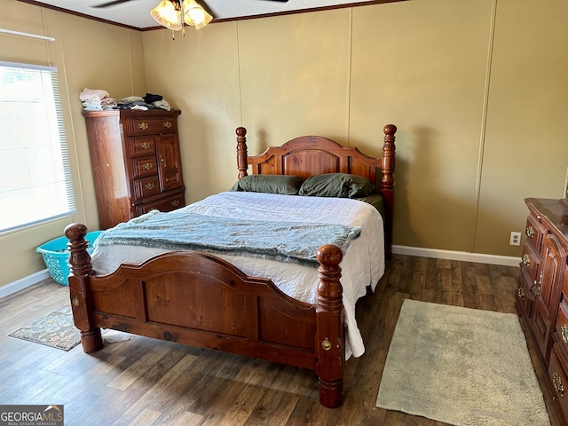 bedroom featuring dark hardwood / wood-style flooring, ceiling fan, multiple windows, and ornamental molding