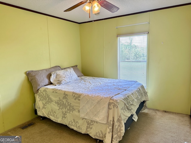 bedroom featuring carpet flooring, ornamental molding, a textured ceiling, and ceiling fan