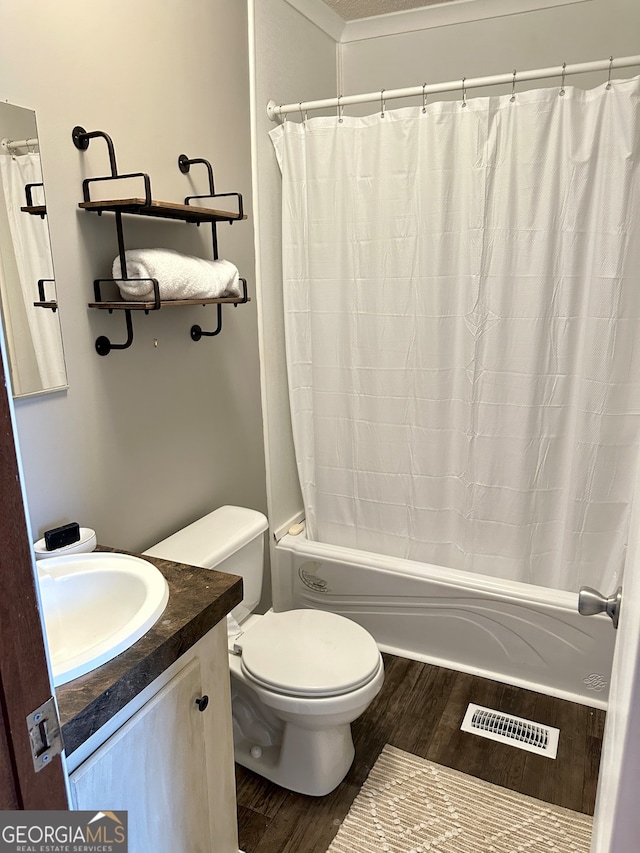 full bathroom featuring wood-type flooring, shower / bath combination with curtain, toilet, and vanity