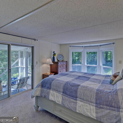 bedroom with light colored carpet and a textured ceiling