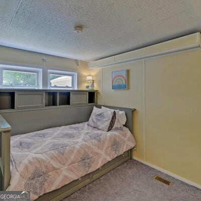 carpeted bedroom with a textured ceiling