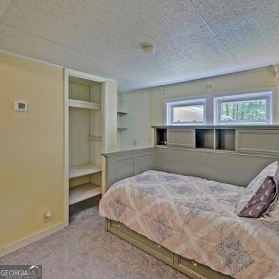 bedroom with light carpet and a textured ceiling