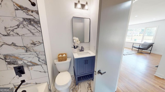 full bathroom featuring vanity, toilet, wood-type flooring, and washtub / shower combination