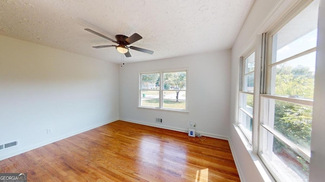 spare room with a textured ceiling, light hardwood / wood-style flooring, and ceiling fan