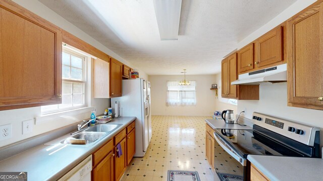 kitchen featuring hanging light fixtures, sink, light tile patterned floors, and white appliances