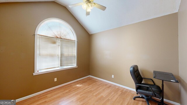 office space featuring vaulted ceiling, ceiling fan, and light hardwood / wood-style flooring