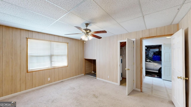 unfurnished bedroom featuring light carpet, a paneled ceiling, ceiling fan, and a closet