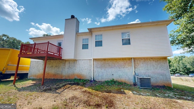 rear view of property featuring cooling unit and a wooden deck