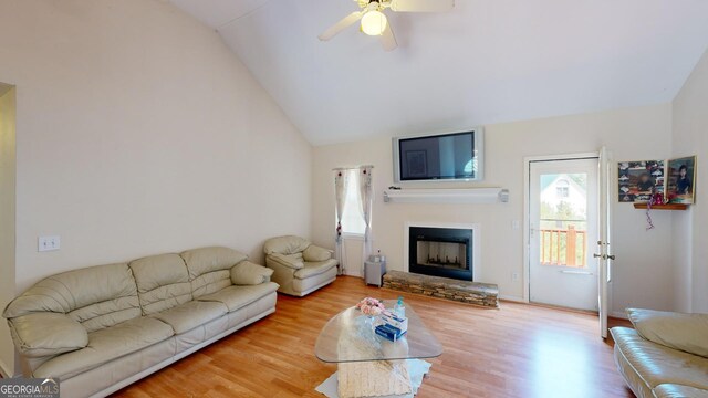 living room with high vaulted ceiling, ceiling fan, and light wood-type flooring