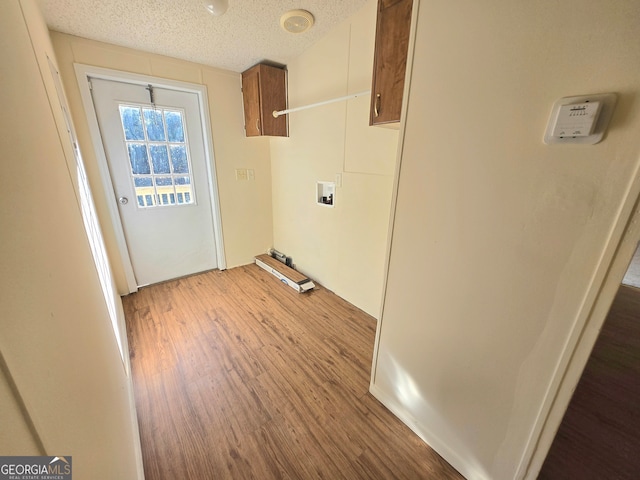 washroom featuring washer hookup, a textured ceiling, and hardwood / wood-style flooring