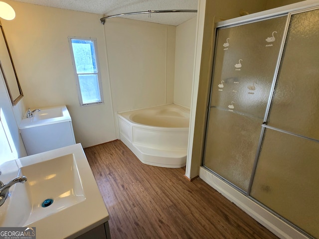 bathroom featuring a textured ceiling, shower with separate bathtub, vanity, and wood-type flooring