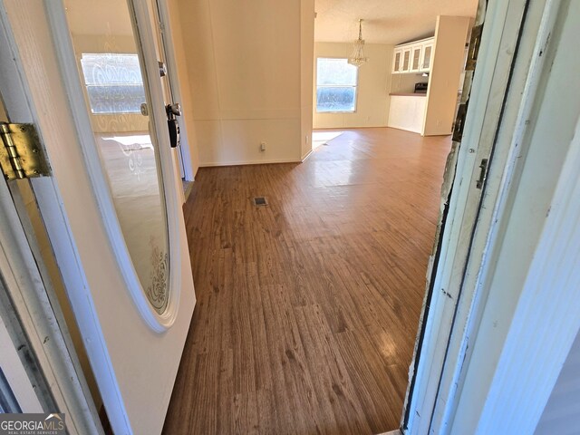 hallway featuring a textured ceiling and dark hardwood / wood-style flooring