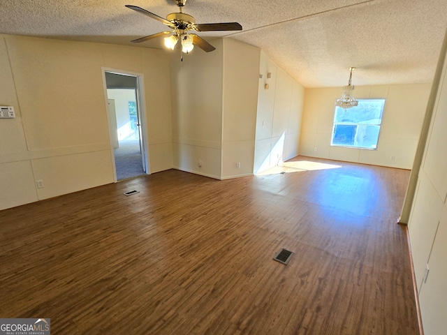 empty room featuring hardwood / wood-style flooring, ceiling fan with notable chandelier, a textured ceiling, and lofted ceiling