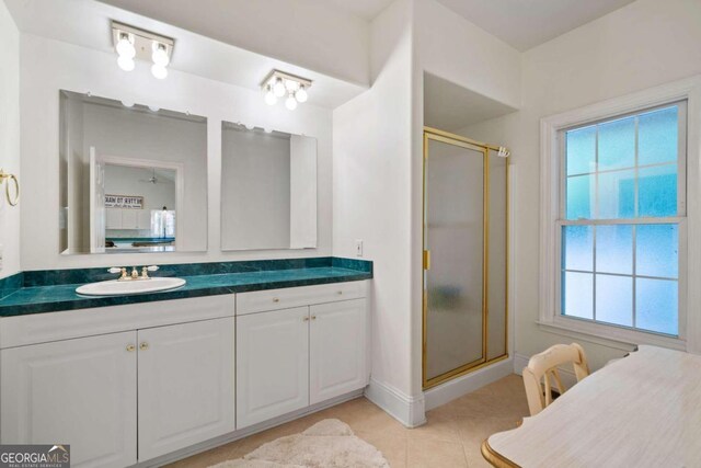 bathroom featuring walk in shower, vanity, and tile patterned flooring