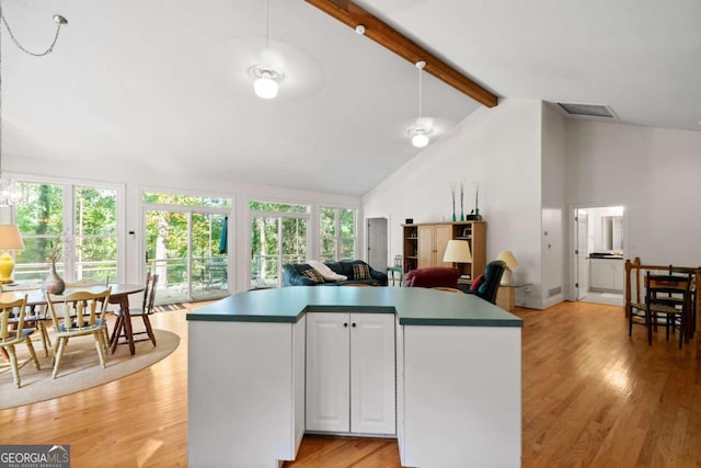 kitchen featuring high vaulted ceiling, beamed ceiling, white cabinets, and light hardwood / wood-style flooring