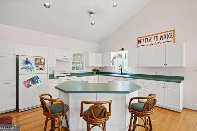 kitchen with a kitchen island, a breakfast bar, white cabinetry, light hardwood / wood-style flooring, and white appliances