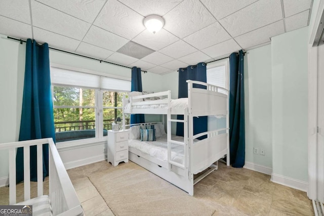 bedroom with a drop ceiling and tile patterned floors