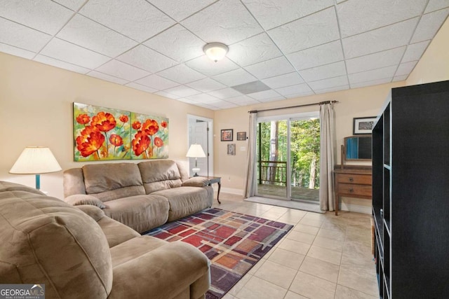 living room featuring a drop ceiling and light tile patterned floors