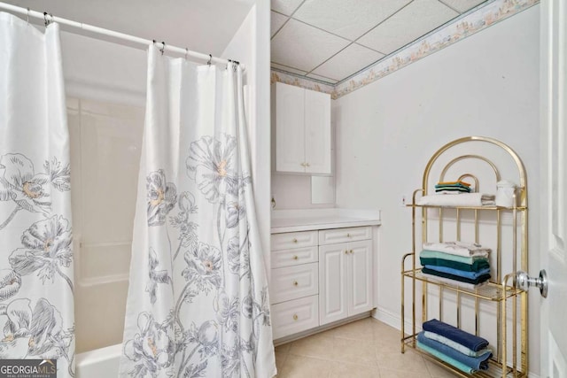 bathroom featuring shower / tub combo, vanity, a drop ceiling, and tile patterned floors