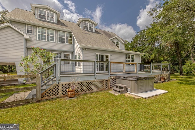 back of property featuring roof with shingles, a lawn, a hot tub, and a wooden deck