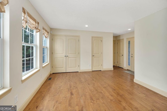 unfurnished bedroom featuring light wood-style floors, recessed lighting, visible vents, and baseboards