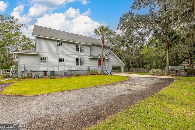 exterior space featuring driveway, a front yard, and fence